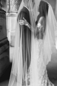 Biltmore Weddings – Marcos and Gaby Black and white photo, close-up of a bride in a lace wedding dress being buttoned up.