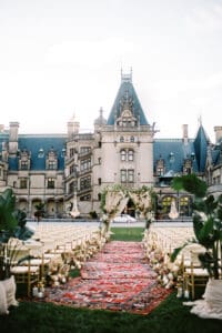 Biltmore Weddings – Marcos and Gaby Wedding aisle lined with Persian rugs leading to floral arch at Biltmore Estate ceremony.
