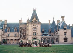 Biltmore Weddings – Marcos and Gaby Wide view of outdoor wedding ceremony at Biltmore Estate with floral arch and guests.
