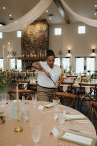 Chestnut Ridge Asheville Wedding_Mikaela + Jacob Asheville wedding planner Terran Ward at Chestnut Ridge lighting candles for wedding reception set up.