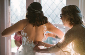 Grand Bohemian Asheville Wedding_Carly and David Bride being zipped into her wedding gown at the Grand Bohemian Asheville. Wedding Planned by luxury Asheville Planner Terran Ward