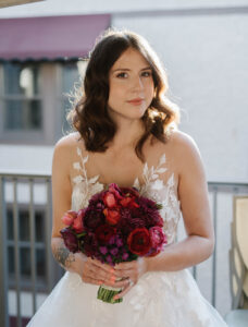 Grand Bohemian Asheville Wedding_Carly and David Close-up of bride holding a red bouquet as she looks at the camera at the Grand Bohemian Asheville. Wedding Planned by luxury Asheville Planner Terran Ward