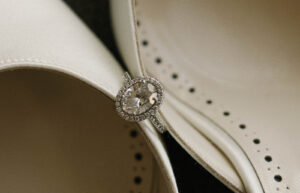 Grand Bohemian Asheville Wedding_Carly and David Close-up of diamond wedding ring between white heels at the Grand Bohemian Asheville. Wedding Planned by luxury Asheville Planner Terran Ward