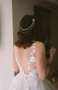 Grand Bohemian Asheville Wedding_Carly and David Close-up of the back of the bride, showcasing the open back of her lace gown and her head piece at the Grand Bohemian Asheville. Wedding Planned by luxury Asheville Planner Terran Ward