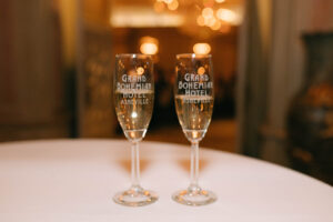 Grand Bohemian Asheville Wedding_Carly and David Close-up of two champagne glasses with the Grand Bohemian Hotel printed on the glass. Wedding Planned by luxury Asheville Planner Terran Ward