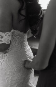 Daniela and Angelo Wedding Grand Bohemian Asheville Black and white close-up of the bride getting buttoned into her lace gown. Wedding Planned by Terran Ward at The Grand Bohemian Asheville