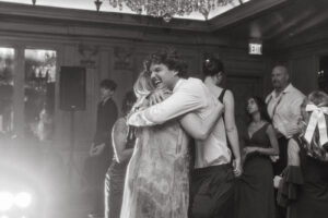 Daniela and Angelo Wedding Grand Bohemian Asheville Black and white photo of wedding guests hugging happily. Wedding Planned by Terran Ward at The Grand Bohemian Asheville