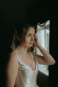 Biltmore Estate Asheville Wedding_Heather + Ben Bride getting ready in her gown with pearl necklace at the Biltmore Estate. Wedding planned by Asheville wedding planner Terran Ward — bold editorial mountain wedding design.