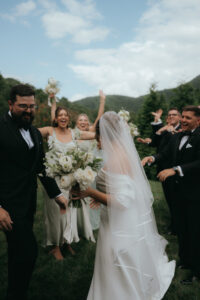 Chestnut Ridge Asheville Wedding – Mikaela + Jacob Bride and groom celebrating with bridal party outdoors at Chestnut Ridge. Wedding planned by Asheville wedding planner Terran Ward — bold editorial design setup.