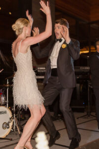 Omni Grove Park Inn Weddings – Mr. and Mrs. Kelly Bride, wearing a fringe white dress, and groom, wearing black tuxedo, dancing energetically at their Omni Grove Park Inn wedding reception