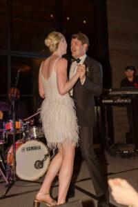 Omni Grove Park Inn Weddings – Mr. and Mrs. Kelly Bride, wearing a fringe white dress, and groom, wearing black tuxedo, smiling and dancing together at their Omni Grove Park Inn reception