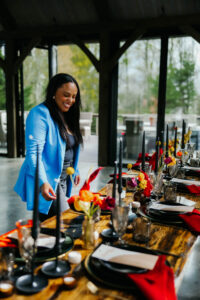 Wedding Planned by Asheville Wedding Planner Terran Ward Asheville wedding planner Terran Ward smiling as she perfects a wedding reception set up. Wedding planned by Asheville wedding planner Terran Ward — bold editorial design setup.