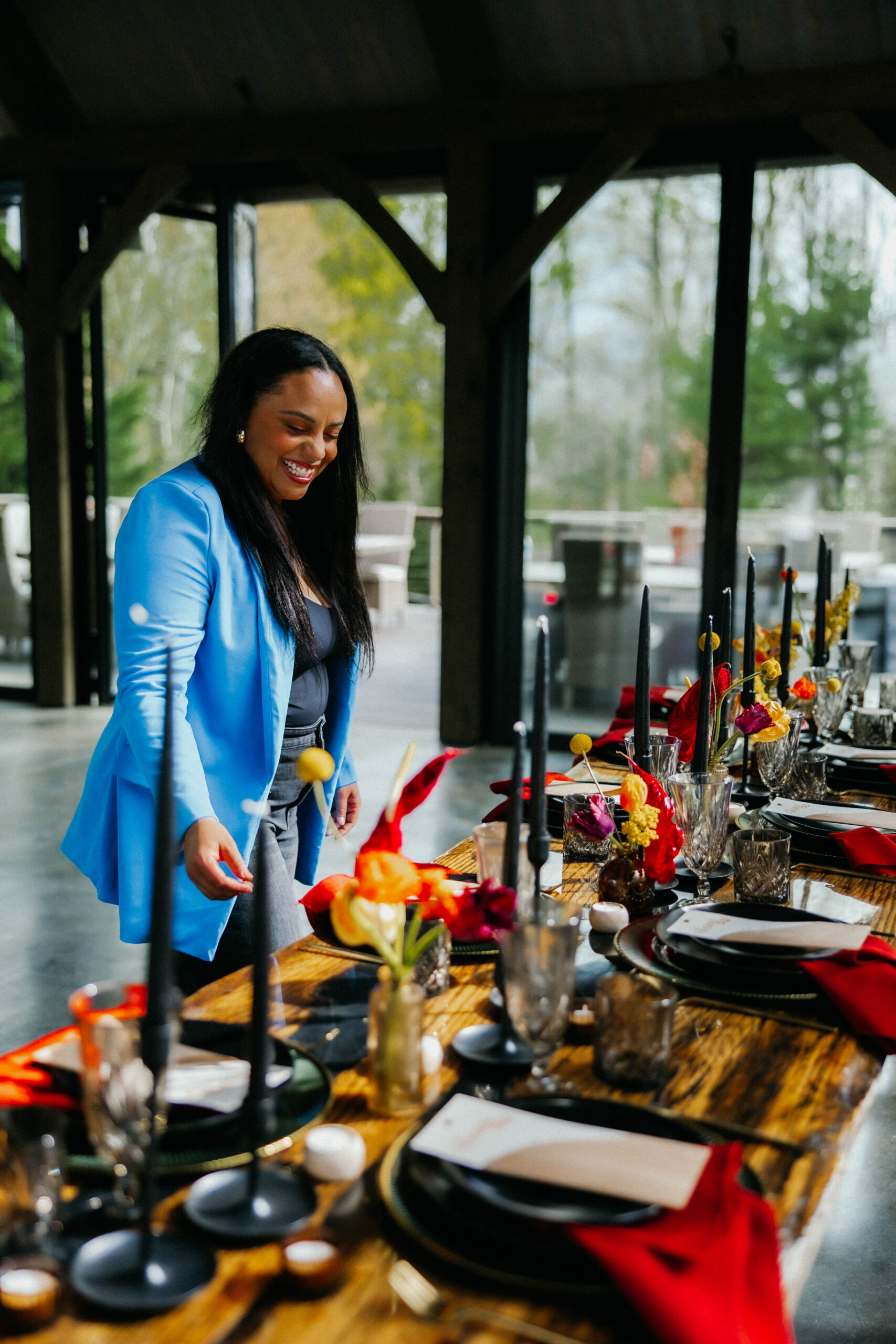 Asheville wedding planner Terran Ward smiling as she perfects a wedding reception set up. Wedding planned by Asheville wedding planner Terran Ward — bold editorial design setup.