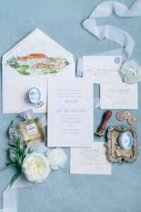 Omni Grove Park Inn Asheville Wedding_Ryan and Lauren Elegant wedding invitation suite with a ring box, Chanel perfume, white flowers, and a watercolor venue illustration. Wedding planned by Asheville wedding planner Terran Ward — bold editorial mountain wedding design.