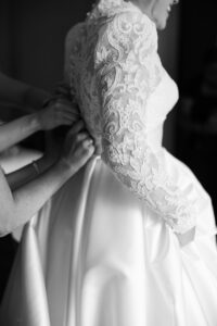 Omni Grove Park Inn Asheville Wedding_Ryan and Lauren Black and white, close-up of bride being buttoned into her wedding gown. Wedding planned by Asheville wedding planner Terran Ward — bold editorial mountain wedding design.