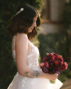 Grand Bohemian Asheville Wedding_Carly and David Side view close-up of bride looking at the red bouquet she is holding at the Grand Bohemian Asheville. Wedding Planned by luxury Asheville Planner Terran Ward