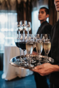 Daniela and Angelo Wedding Grand Bohemian Asheville Server holding champagne and wine glasses on a silver tray at the Grand Bohemian. Wedding Planned by Terran Ward at The Grand Bohemian Asheville