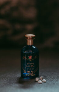 Daniela and Angelo Wedding Grand Bohemian Asheville Close-up of a Gucci perfume bottle with earrings next to it. Wedding Planned by Terran Ward at The Grand Bohemian Asheville