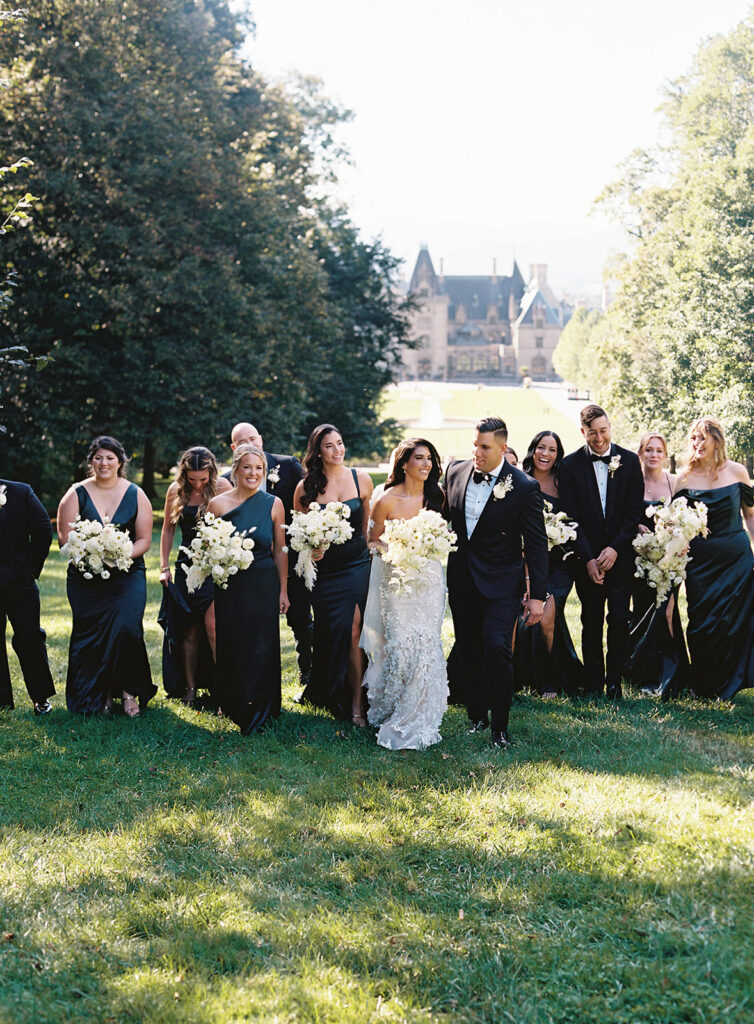 Wedding couple posing happily with bridesmaids and groomsmen in the gardens of the Biltmore Estate. Wedding planned by Terran Ward