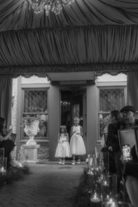 Daniela and Angelo Wedding Grand Bohemian Asheville Black and white photo of young flower girls right before they walk down the aisle in an outside tent. Wedding Planned by Terran Ward at The Grand Bohemian Asheville