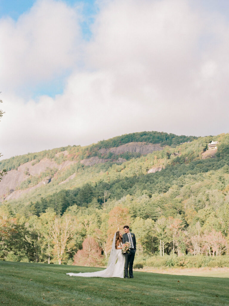 Couple looking at each other romantically with mountains and trees from the Lonesome Valley in the background. Wedding planned by Terran Ward