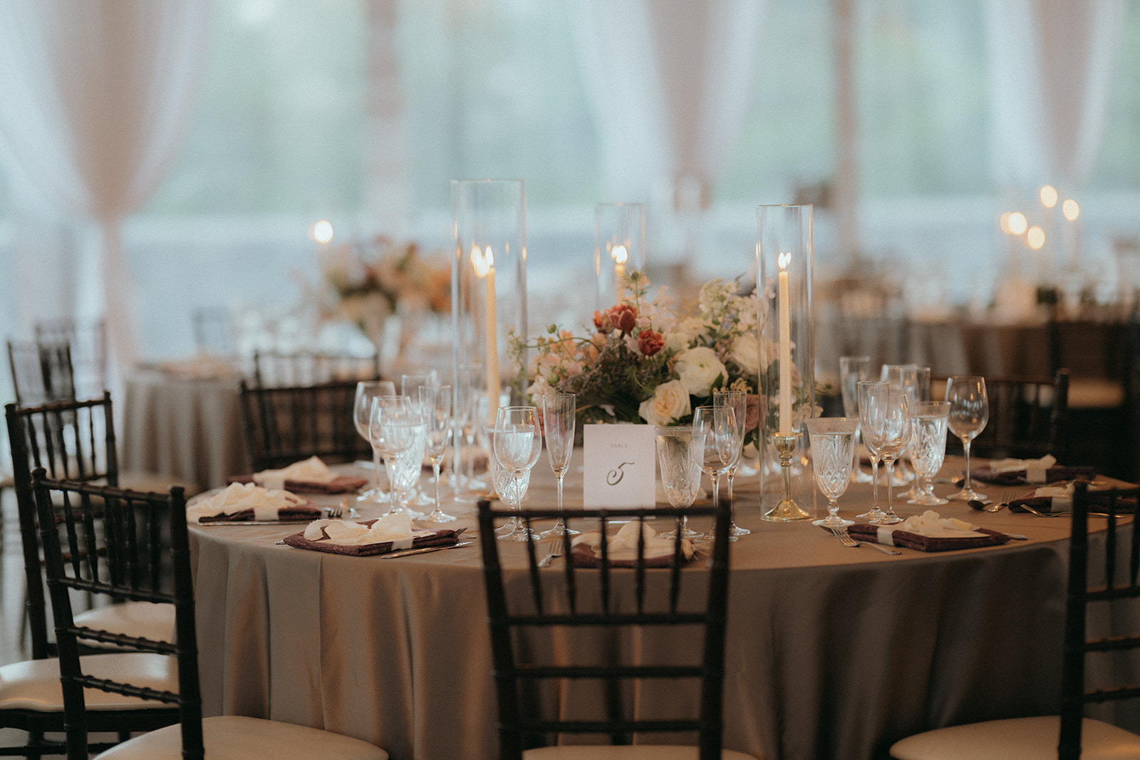 Close-up of reception table set up at the Biltmore Estate featuring maroon napkins, black chairs, and silky grey tablecloth. Asheville wedding planner Terran Ward creating luxury weddings with a budget.