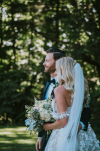 Side view of bride and groom as they look off camera; groom has an arm around the bride. Asheville micro wedding — modern editorial setup by Terran Ward
