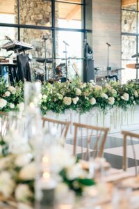 Stage set-up with elegant florals in front of the stage. Asheville wedding planner Terran Ward creating luxury weddings with a budget.
