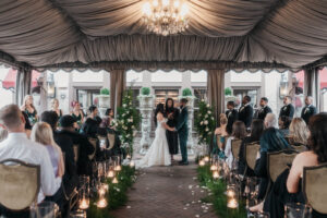 Bride and groom standing before the officiant, happily, under a tent at the Grand Bohemian Asheville. Asheville micro wedding — modern editorial setup by Terran Ward